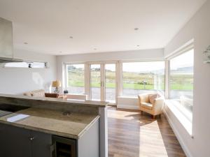 a kitchen with a large window and a living room at Purteen in Achill