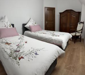two beds sitting next to each other in a room at Au parfum des roses in Gunstett