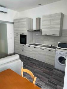 una cucina con armadi bianchi e una lavatrice/asciugatrice di Palombino Apartment a Milano