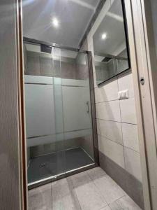 una doccia con porta in vetro in bagno di Palombino Apartment a Milano