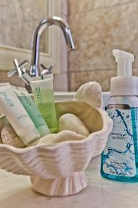 a bathroom counter with a sink with towels and a bottle of soap at Villa Stamatina in Kyra Panagia