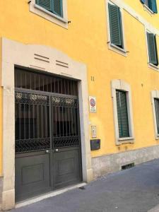 um edifício amarelo com uma grande porta e janelas em Palombino Apartment em Milão