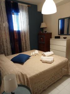 a bedroom with a bed with towels on it at La casa di Martina in Acitrezza