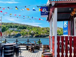 un patio con mesas y sillas y vistas al agua en Holiday home RÖNNÄNG VI, en Rönnäng