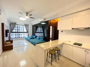 a kitchen and living room with a blue couch at Vsummer, Homely Suite by Antlerzone in Johor Bahru