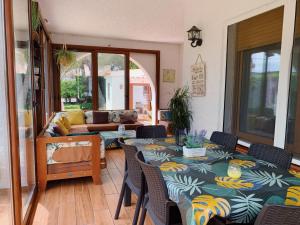 a living room with a table and chairs and a couch at Villa los sauces in L'Ametlla de Mar