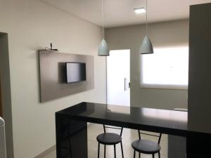 una sala da pranzo con tavolo nero e sgabelli di Vêneto Flat Residence (AP-02) a Primavera do Leste