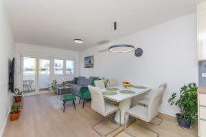 een eetkamer en woonkamer met een tafel en stoelen bij Modern living apartment Airy in Split