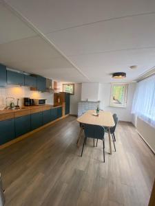 cocina y comedor con mesa y sillas en Aangename en zeer rustig gelegen vakantiewoning en Westdorpe