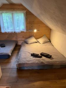 1 dormitorio con 2 camas en una cabaña de madera en Namiņš Guntas, en Uguņi