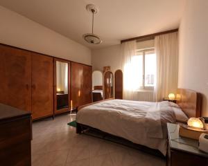 a bedroom with a bed and a desk and a window at Spadini Apartment in Bologna