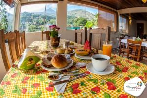 a table with plates of food and a cup of coffee at Pousada Manga Rosa in Ilhabela