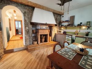 a kitchen with a fireplace and a table and a dining room at casa Virginia nel borgo in Lierna