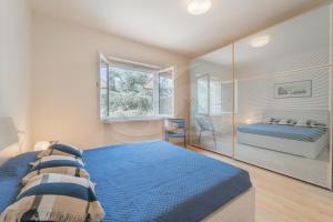 una camera con un letto blu e una finestra di A Casa di Massi - Goelba a Portoferraio