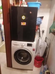 uma máquina de lavar e secar roupa num pequeno quarto em Rustico Chiara em Sonogno