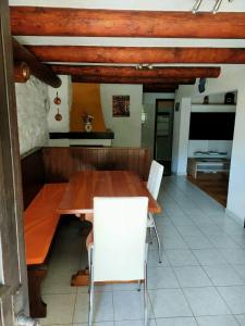 a dining room with a wooden table and white chairs at Rustico Chiara in Sonogno