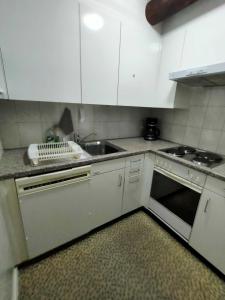 a small kitchen with white cabinets and a sink at Rustico Chiara in Sonogno