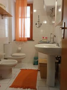 a bathroom with a sink and a toilet at La casa di Martina in Acitrezza