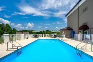 a swimming pool on a patio with a building at avid hotel Fort Payne by IHG in Fort Payne