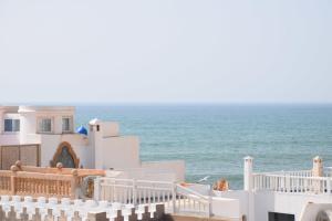 a beach scene with a large white house at Riad Saltana in Essaouira