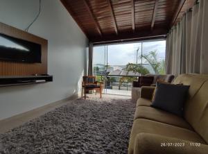 a living room with couches and a flat screen tv at Pousada com vista para o Cristo 3 in Encantado