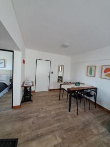 Zimmer mit einem Tisch, Stühlen und einem Bett in der Unterkunft Departamento La Restinga - La Perla in Mar del Plata
