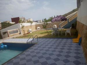 vista sulla piscina con tavolo e sedie di Amsa aqua villa a Tétouan