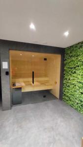 a room with a wall with green ivy at Cicha Przystań Apartamenty WhiteBlue sauna&fitness&parking in Kołobrzeg