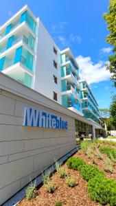 a building with a sign on the side of it at Cicha Przystań Apartamenty WhiteBlue sauna&fitness&parking in Kołobrzeg