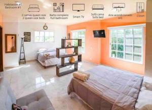 a bedroom with orange walls and a bed and a tv at CASA 24 PAX A 5 MIN DE LA PLAYA in Puerto Morelos