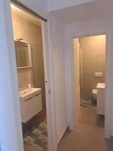 a white bathroom with a sink and a toilet at Villa Magica in Pirovac