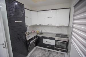 a small kitchen with white cabinets and a sink at Apartment LUX 2 in Tuzla
