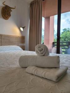Un dormitorio con una cama con una toalla. en Apartamentos Rurales El Mirador de San Juan en Cangas de Onís