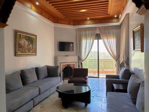 - un salon avec un canapé et une table dans l'établissement palmeraie village 2, à Marrakech