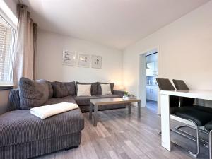 uma sala de estar com um sofá e uma mesa em Stilvolles, frisch renoviertes 2Zi Apartment mit Küche und Balkon in Kliniknähe em Bad Oeynhausen