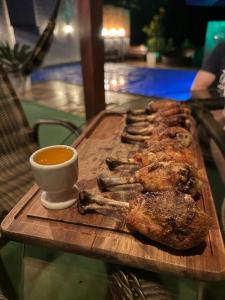 ein Holzschnitttafel mit Fleisch und einer Tasse Kaffee in der Unterkunft Casa do Lago Pinhal in Rio dos Cedros