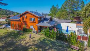an orange house with solar panels on top of it at Casa do Lago Pinhal in Rio dos Cedros