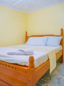 a bedroom with a wooden bed with blue pillows at Entire Fully furnished Villas in Kisii in Kisii