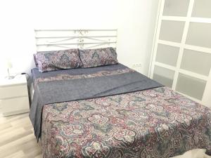 ein Schlafzimmer mit einem Bett mit gemusterter Decke in der Unterkunft BorrullApart in Valencia
