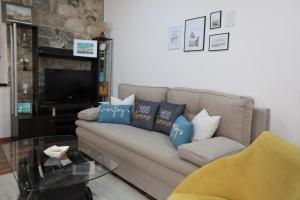a living room with a couch with blue pillows at Apartment in a stone building by the Adriatic Sea in Kaštela