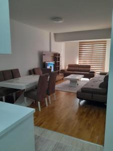 - un salon avec un canapé, une table et des chaises dans l'établissement Luxsary Home in Skopje, à Skopje