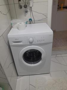 Un lave-linge blanc est installé dans la salle de bains. dans l'établissement Luxsary Home in Skopje, à Skopje
