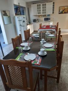 a dining room with a black table with plates and chairs at Meu cantinho in Serra Negra