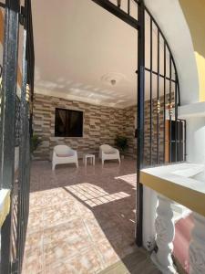 een kamer met een terras met 2 stoelen en een televisie bij Casa Francesca in Boca Chica