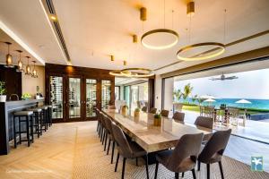 uma sala de jantar com uma mesa longa e vista para o oceano em Sunny Vacation Villa No 33 em Bonao