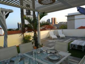 una mesa y sillas en la azotea de un edificio en Terraza del Atlántico, un oasis en la ciudad, en Santa Cruz de Tenerife