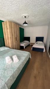 twee bedden in een kamer met groene muren bij Host Elios Tirana in Tirana