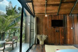 a room with a screened in porch with a tv at Wilderness Treehouse in Doi Saket