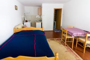 a bedroom with a bed and a table and a kitchen at Vila Savinka in Zlatibor