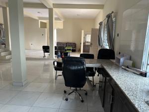 uma cozinha com um balcão e cadeiras num quarto em Kams Lodge Broadview, Idu em Furah